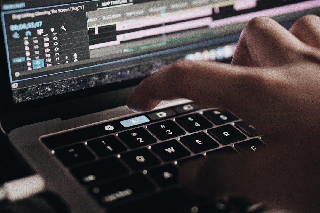 Close-up of hands editing a video timeline on a laptop